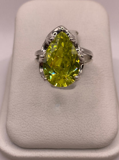 Anillo solitario de plata .925 con circonia pera verde lima sobre estuche blanco, vista frontal