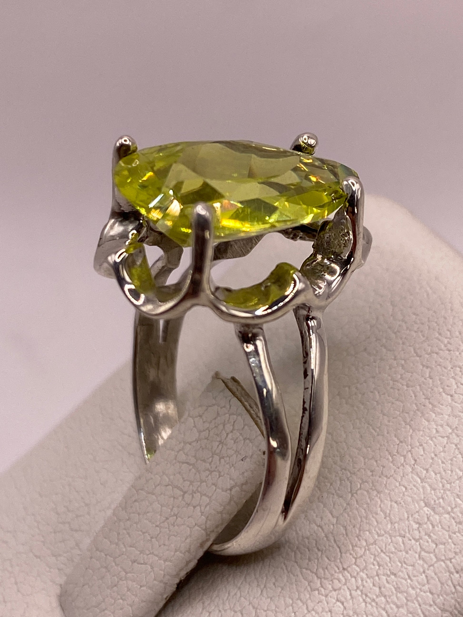Detalle del engaste calado y garras decorativas del anillo de plata con circonia pera verde lima