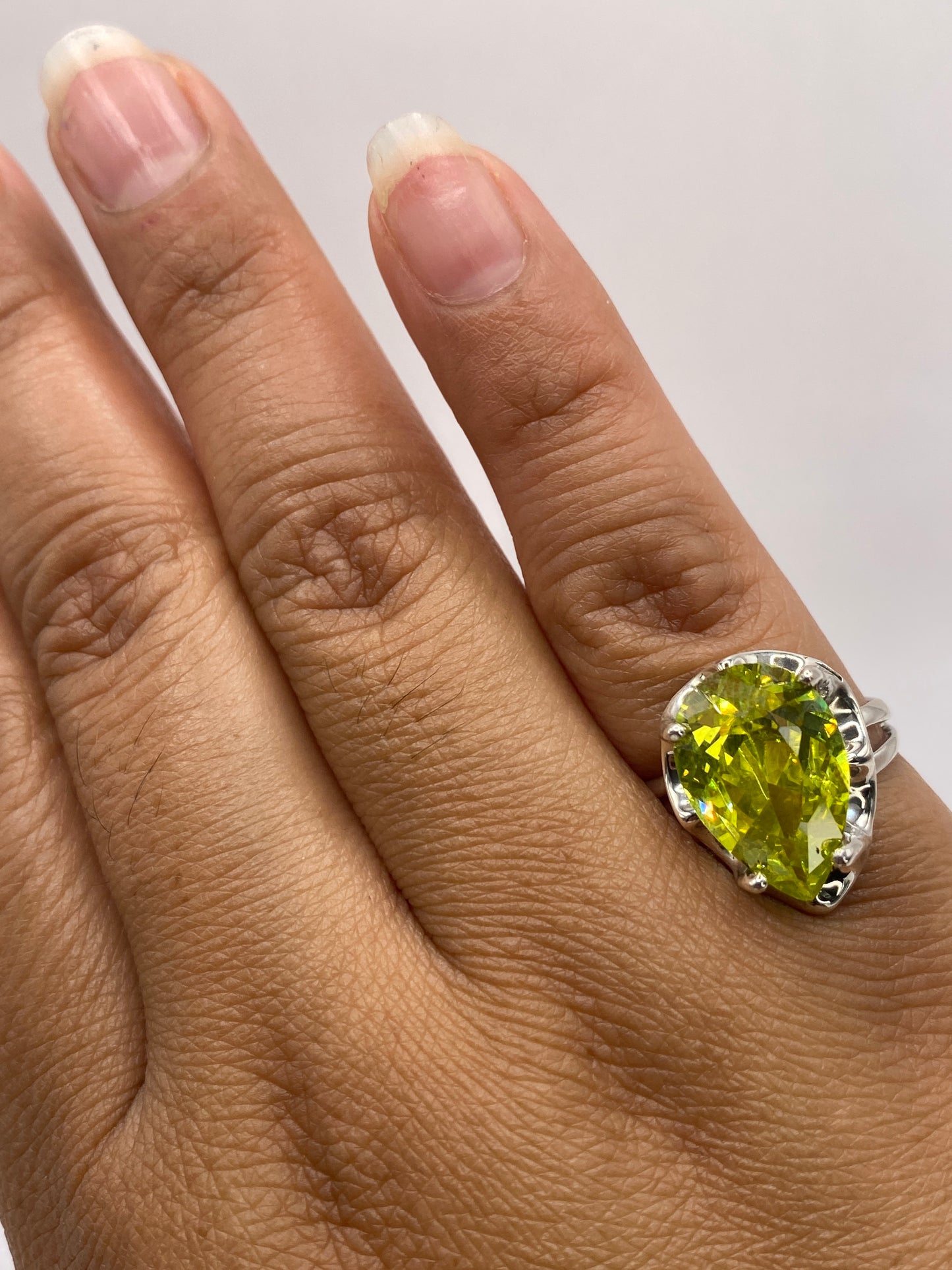 Anillo solitario verde lima de plata .925 puesto en la mano de una mujer, talla 6