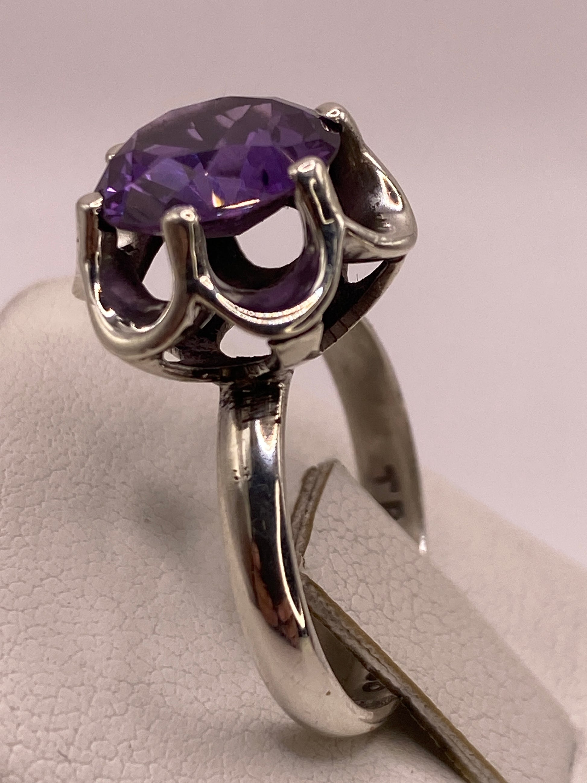 Detalle del engaste de circonia oval morada con garras dobles y montura calada en plata de Taxco