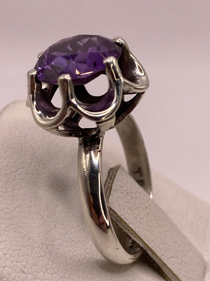 Detalle del engaste de circonia oval morada con garras dobles y montura calada en plata de Taxco