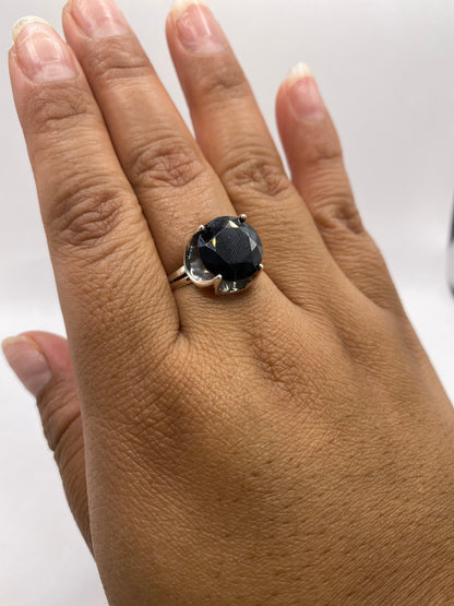 Anillo solitario de circonia negra oval puesto en la mano de una mujer, mostrando escala y presencia en dedo