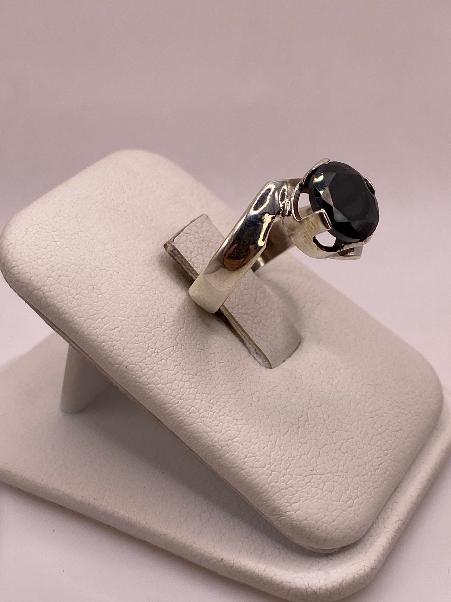 Vista lateral del anillo elegante mostrando la banda de plata .925 y el engaste de la circonia