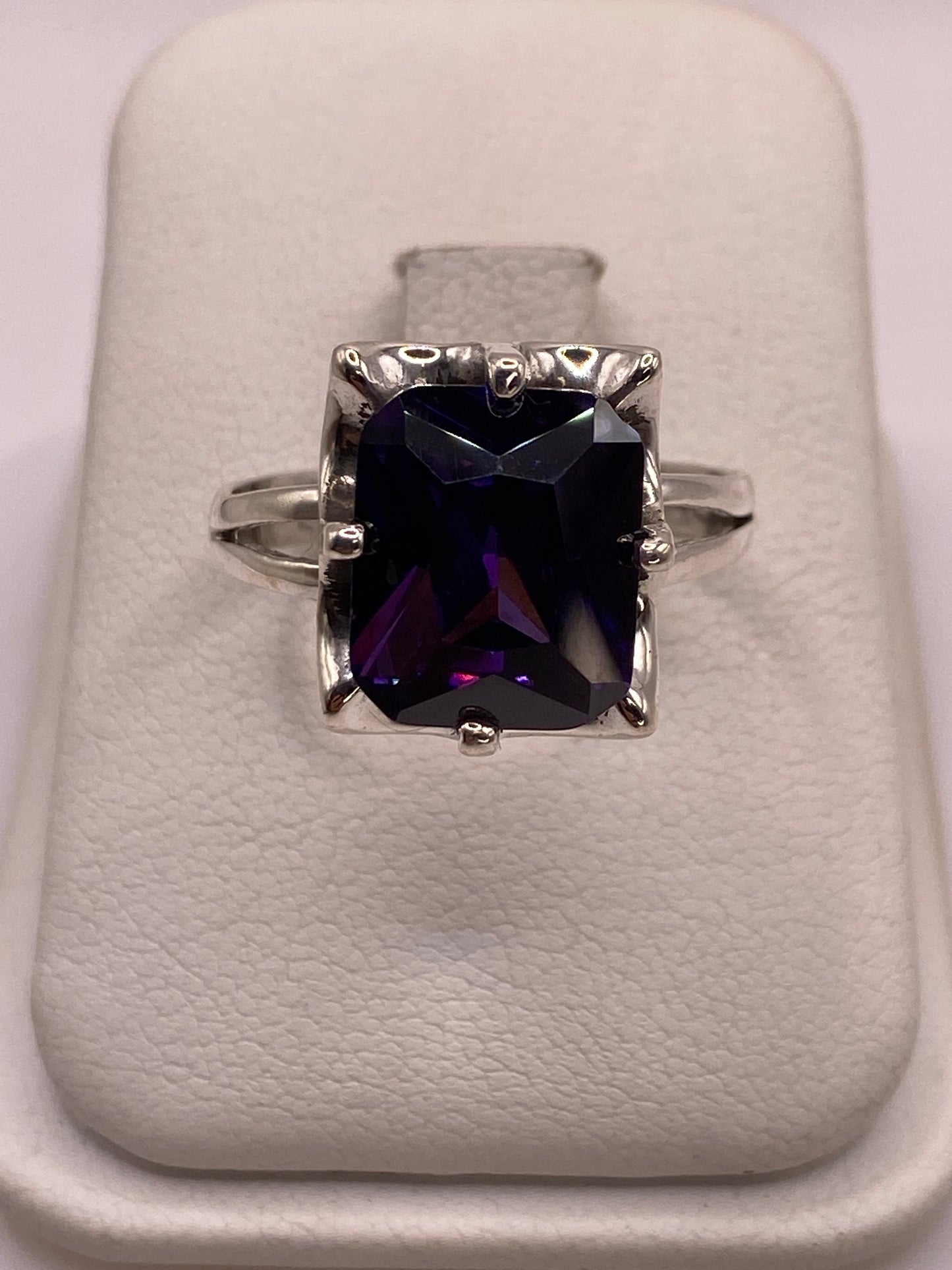 Anillo solitario de plata con circonia púrpura profundo en mano de mujer