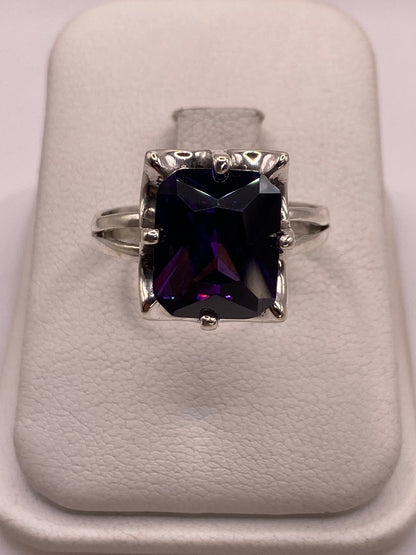 Anillo solitario de plata con circonia púrpura profundo en mano de mujer