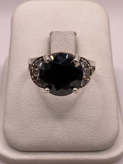 Anillo solitario de plata con circonia ovalada incolora, vista frontal sobre almohada blanca