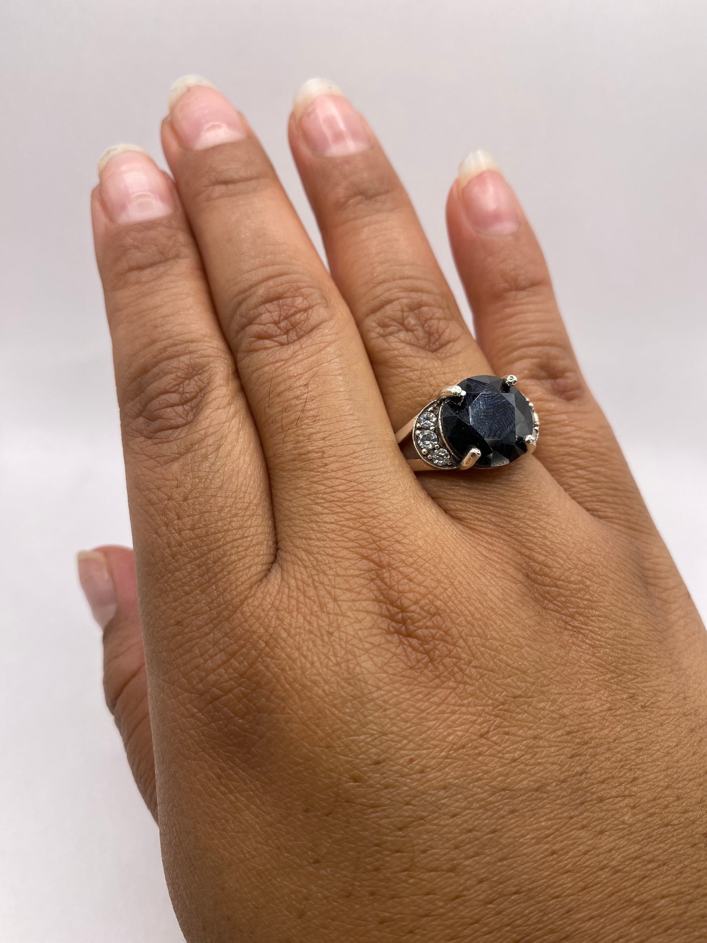 Anillo solitario colocado en dedo de mujer, mostrando brillo diamantino de la circonia