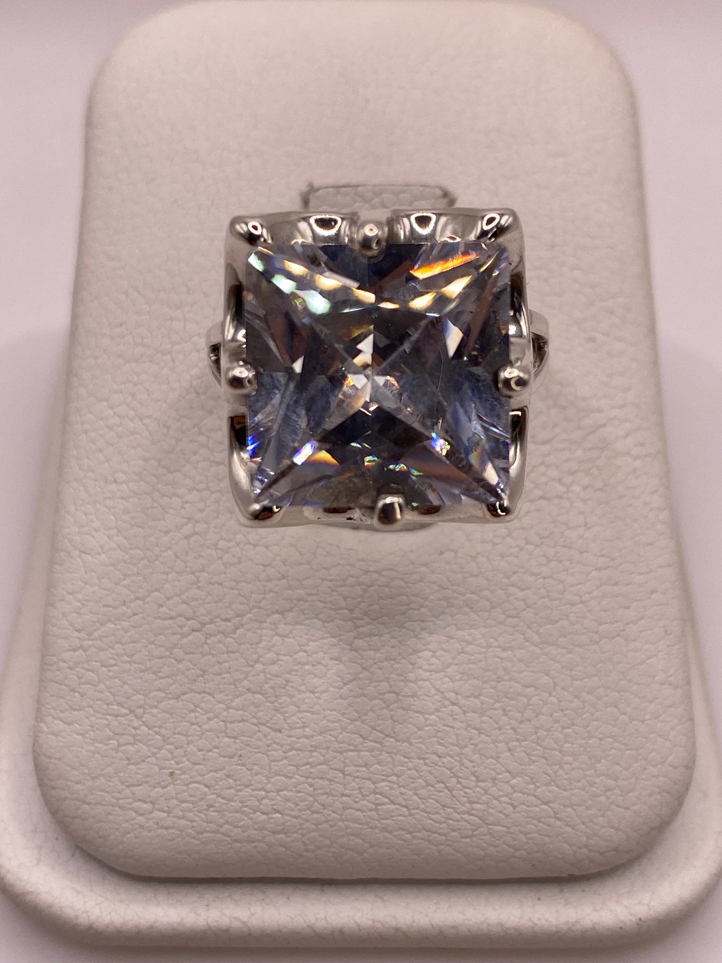 Anillo solitario de plata .925 con circonia blanca cuadrada, frente 10 mm, sobre almohada blanca