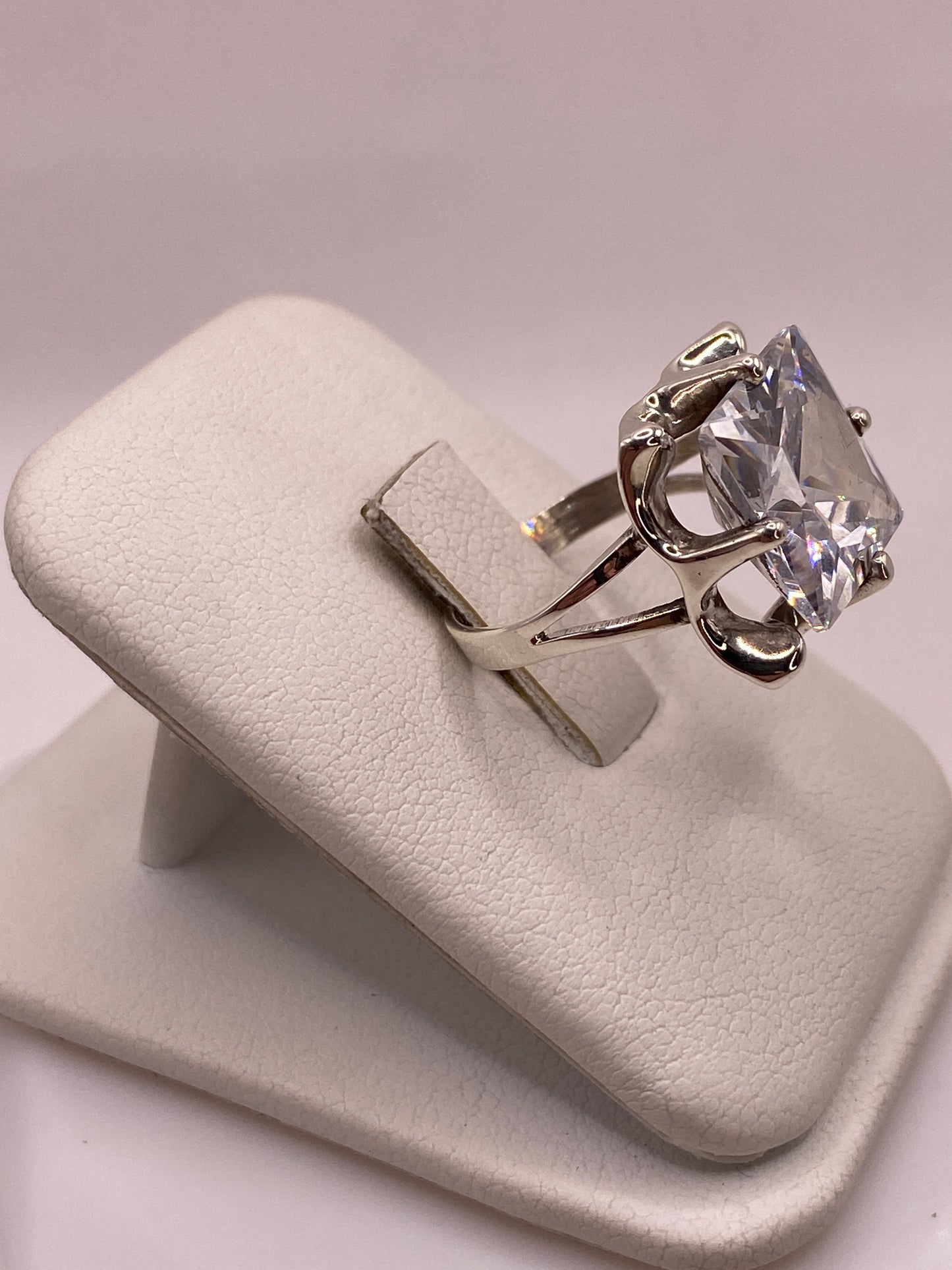 Anillo solitario de plata con circonia engastada, vista lateral mostrando la banda de 4 mm y el perfil del montaje