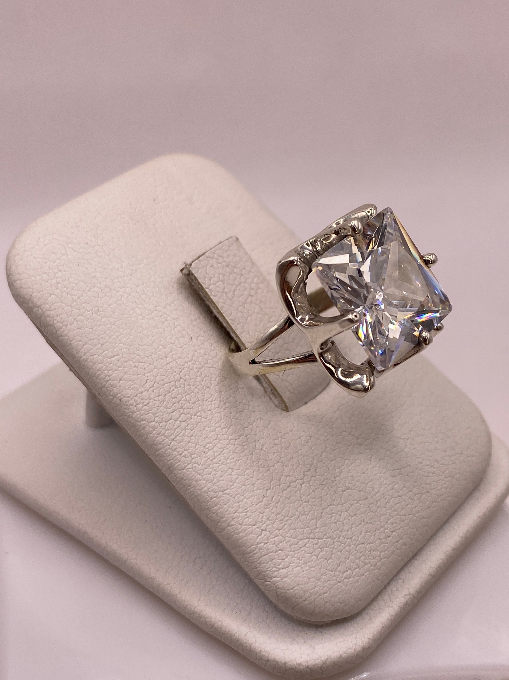 Anillo coctel de plata con circonia blanca reflejando luz como diamante, vista frontal