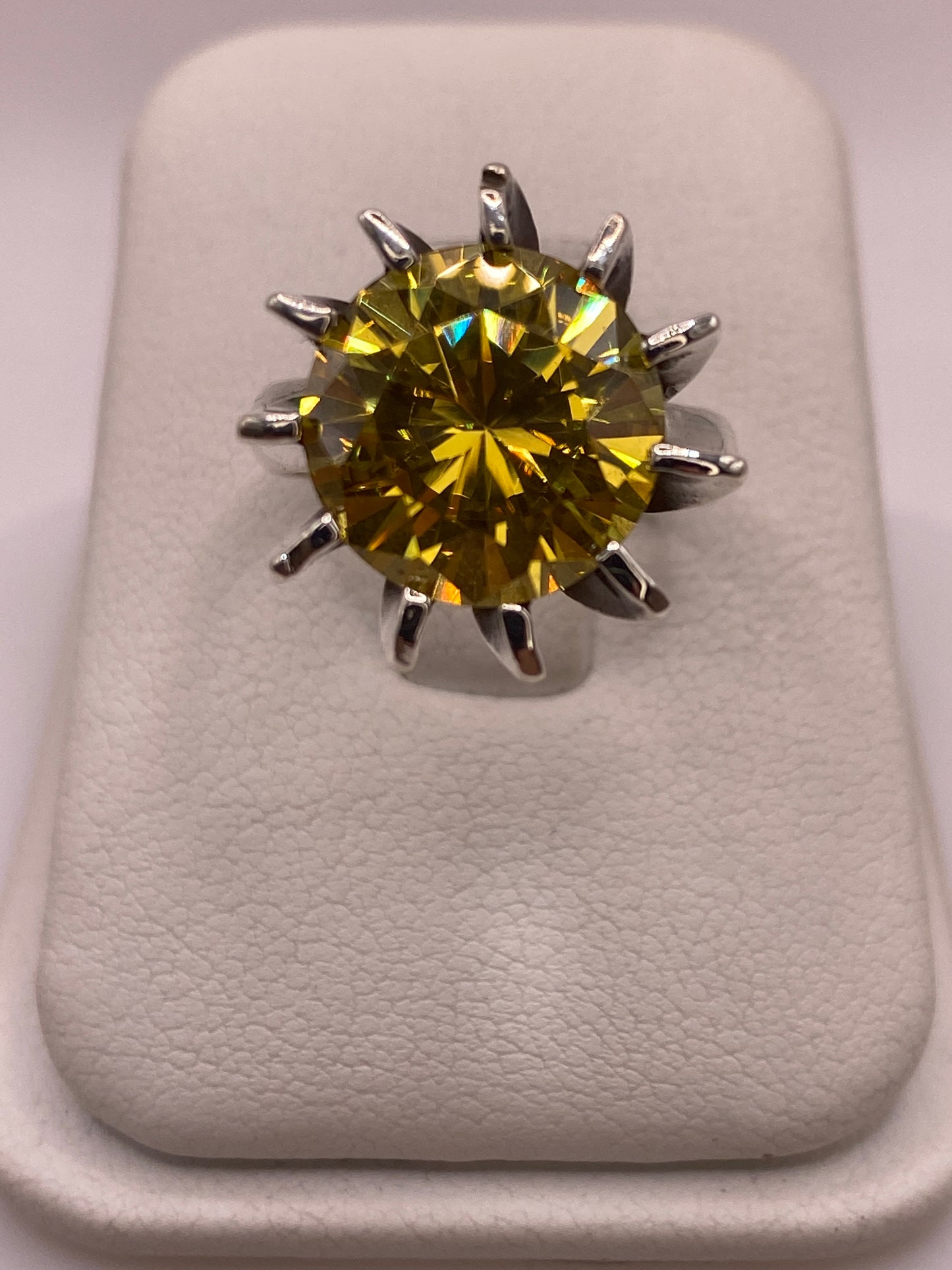 Anillo solitario de plata .925 con circonia amarillo oro en forma frontal, mostrando el engaste de púas