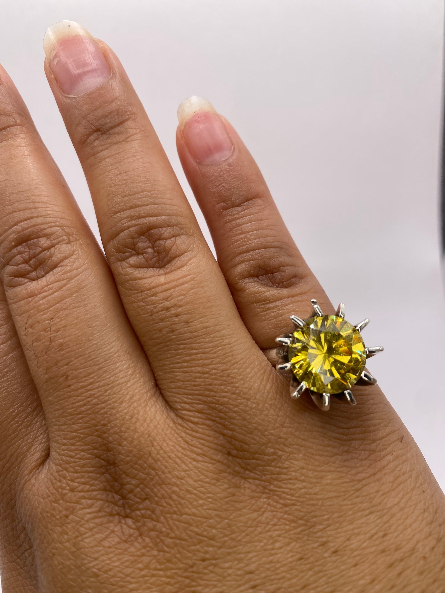 Anillo puesto en el dedo, circonia amarilla capturando luz, estilo clásico y elegante