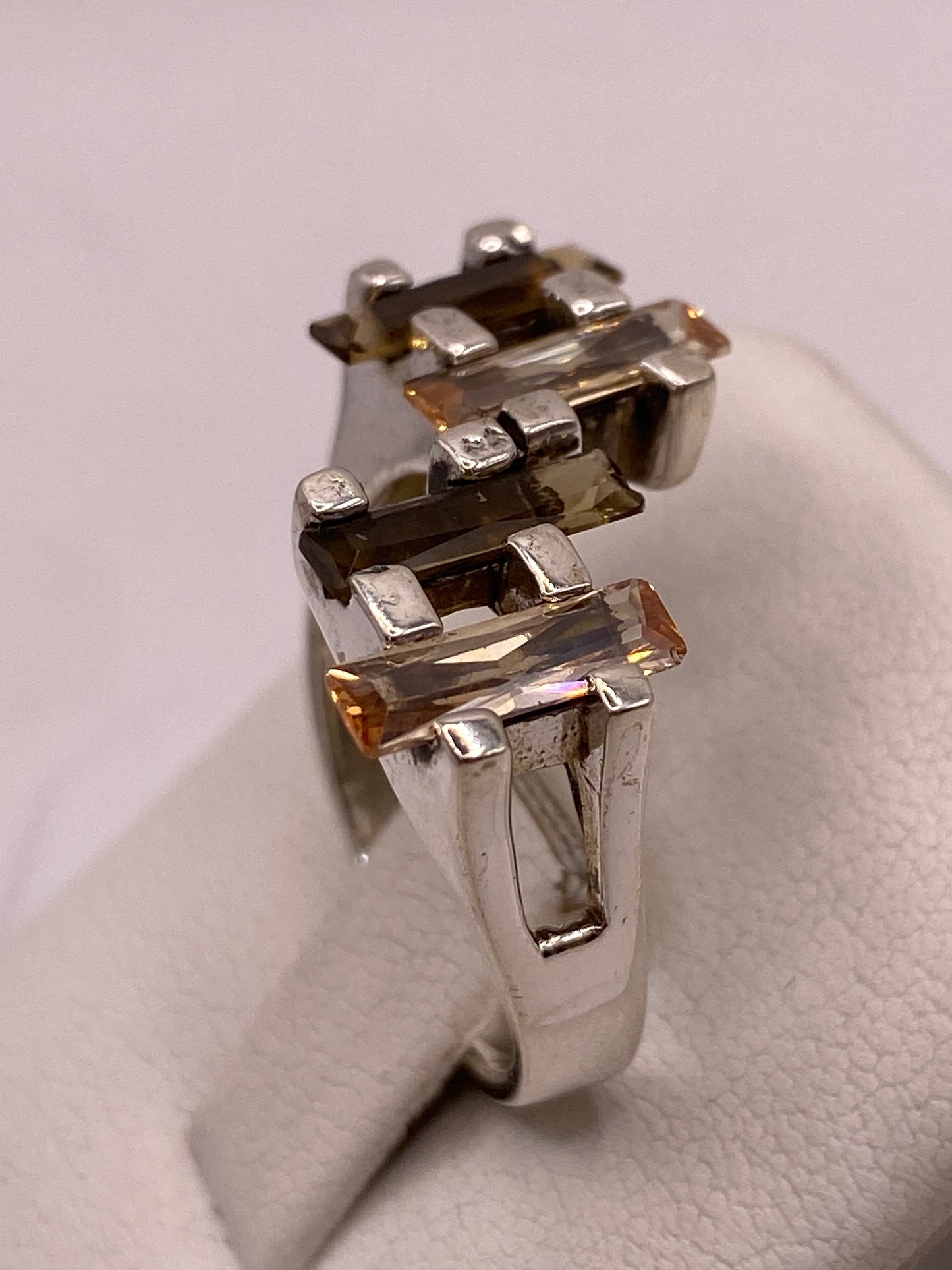 Detalle del frente del anillo con las 5 circonias facetadas en tono ámbar dorado