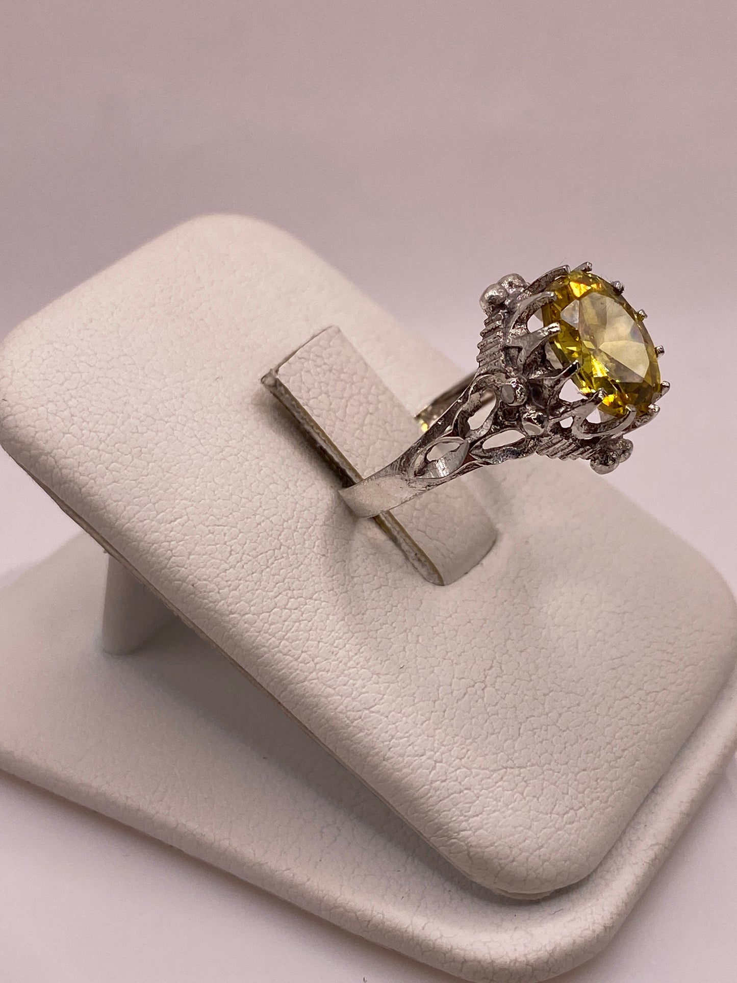 Vista lateral del anillo de plata con filigrana vintage y piedra amarilla engastada