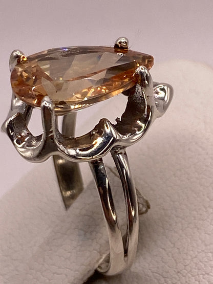 Anillo solitario de plata en la mano mostrando el brillo ámbar dorado de la piedra