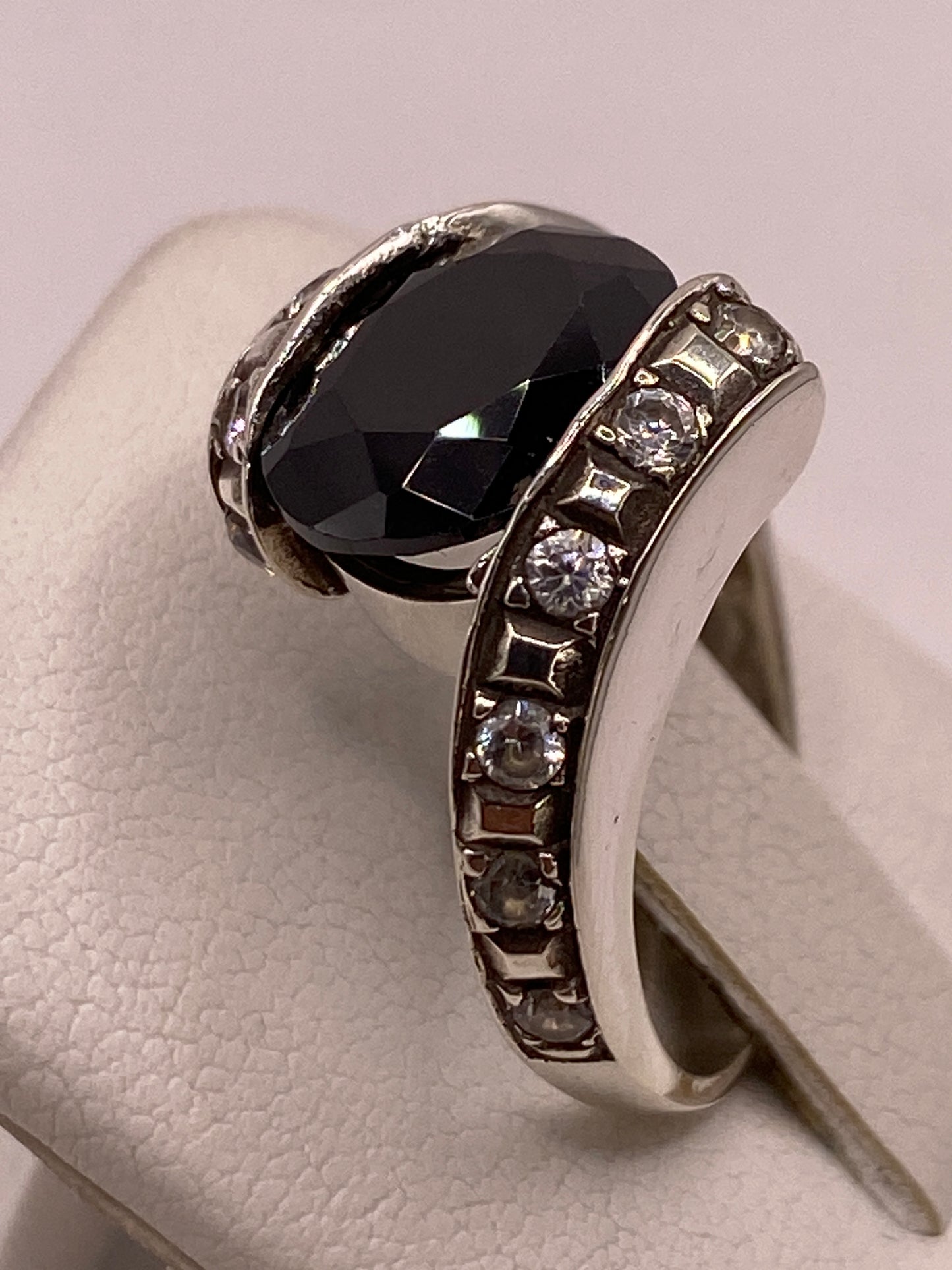 Detalle lateral del anillo en plata sobre fondo blanco, perfil de banda texturizada con sello 925