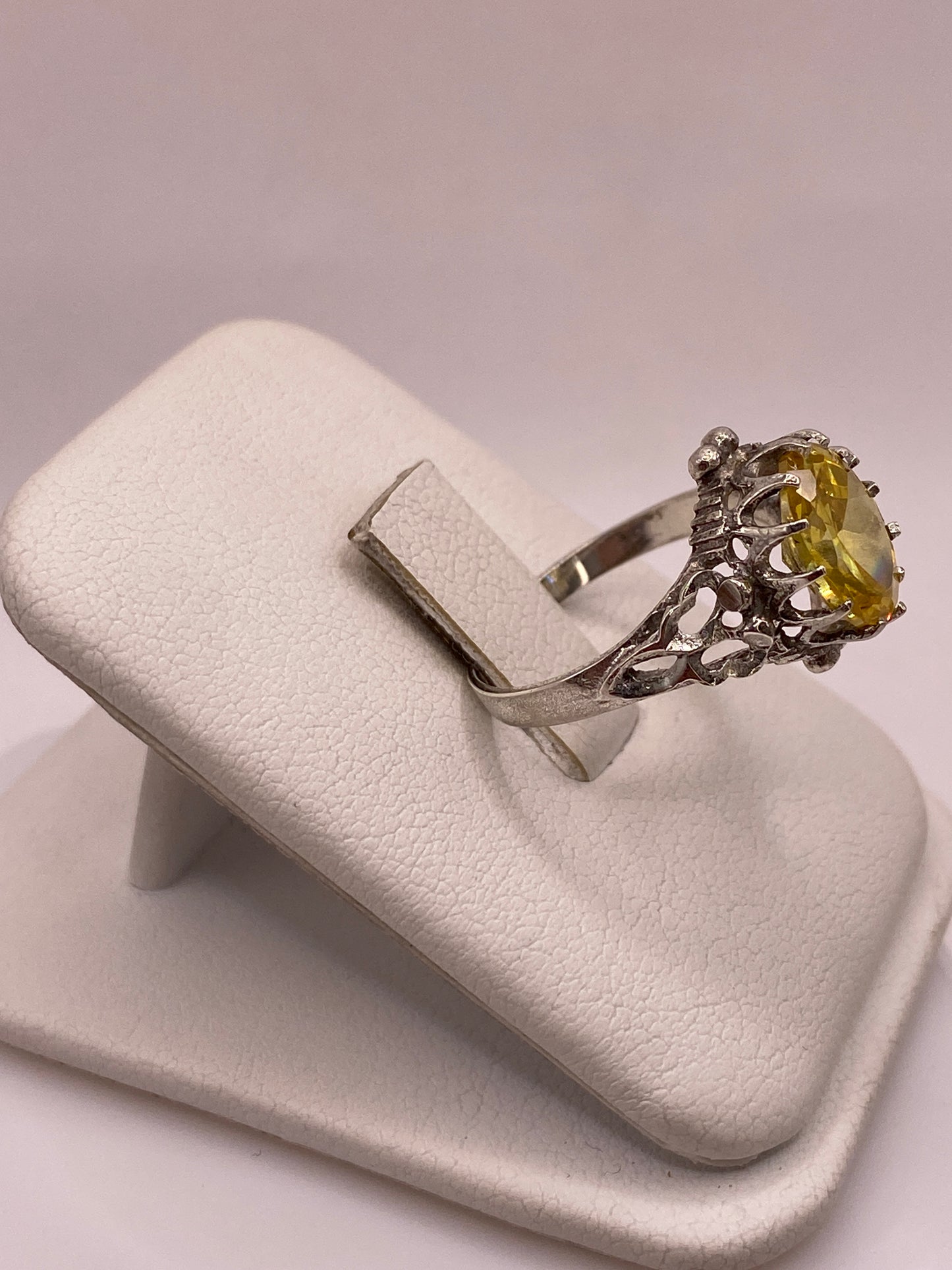 Anillo de coctel vintage en plata visto de lado, mostrando los detalles ornamentales del engaste