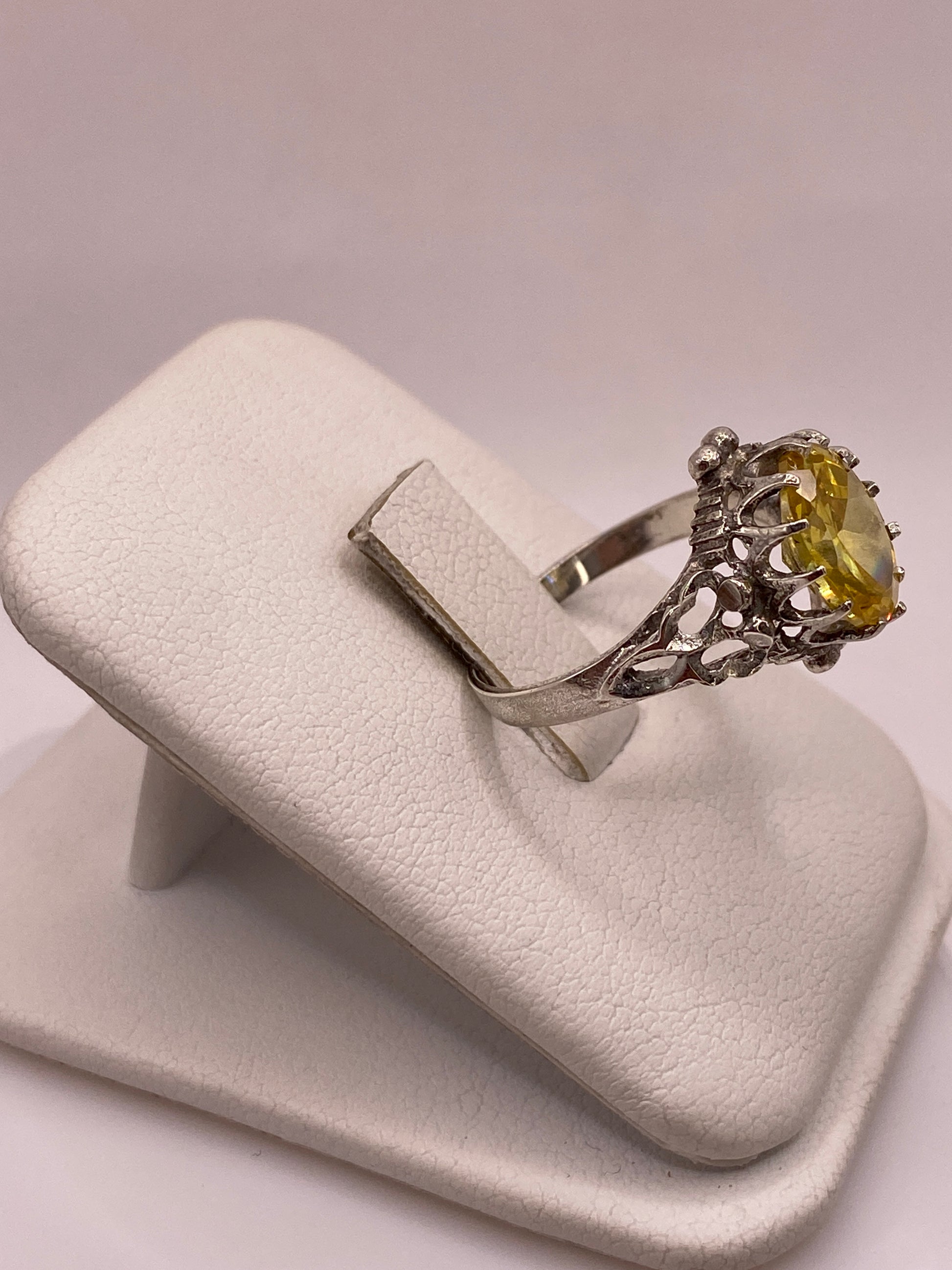 Anillo de coctel vintage en plata visto de lado, mostrando los detalles ornamentales del engaste