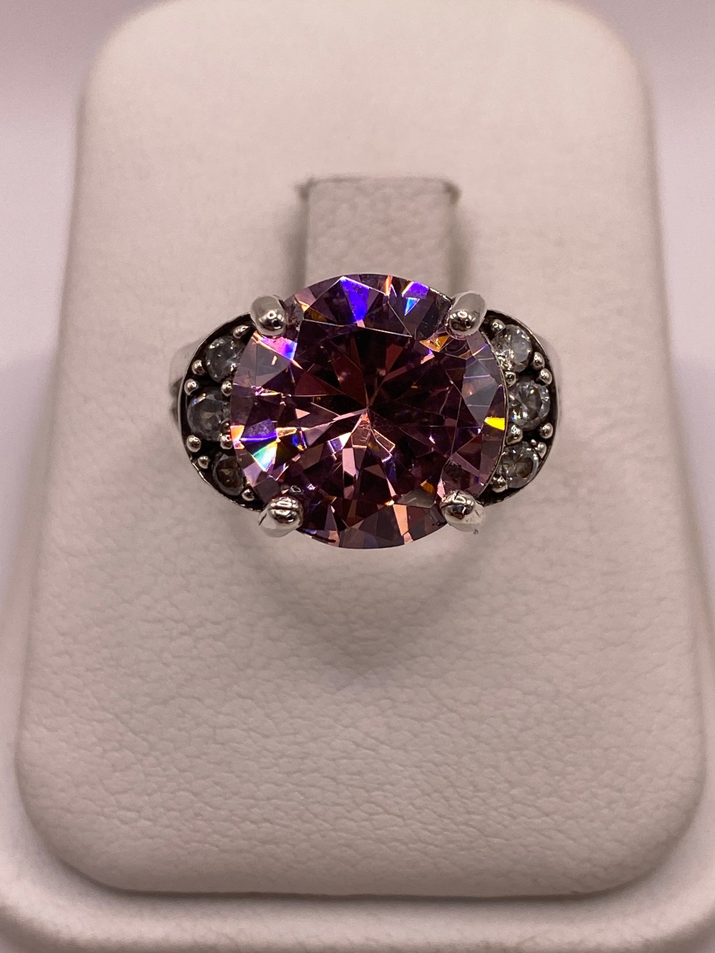 Anillo de plata coctel con circonia púrpura ovalada y pequenas circonias blancas laterales