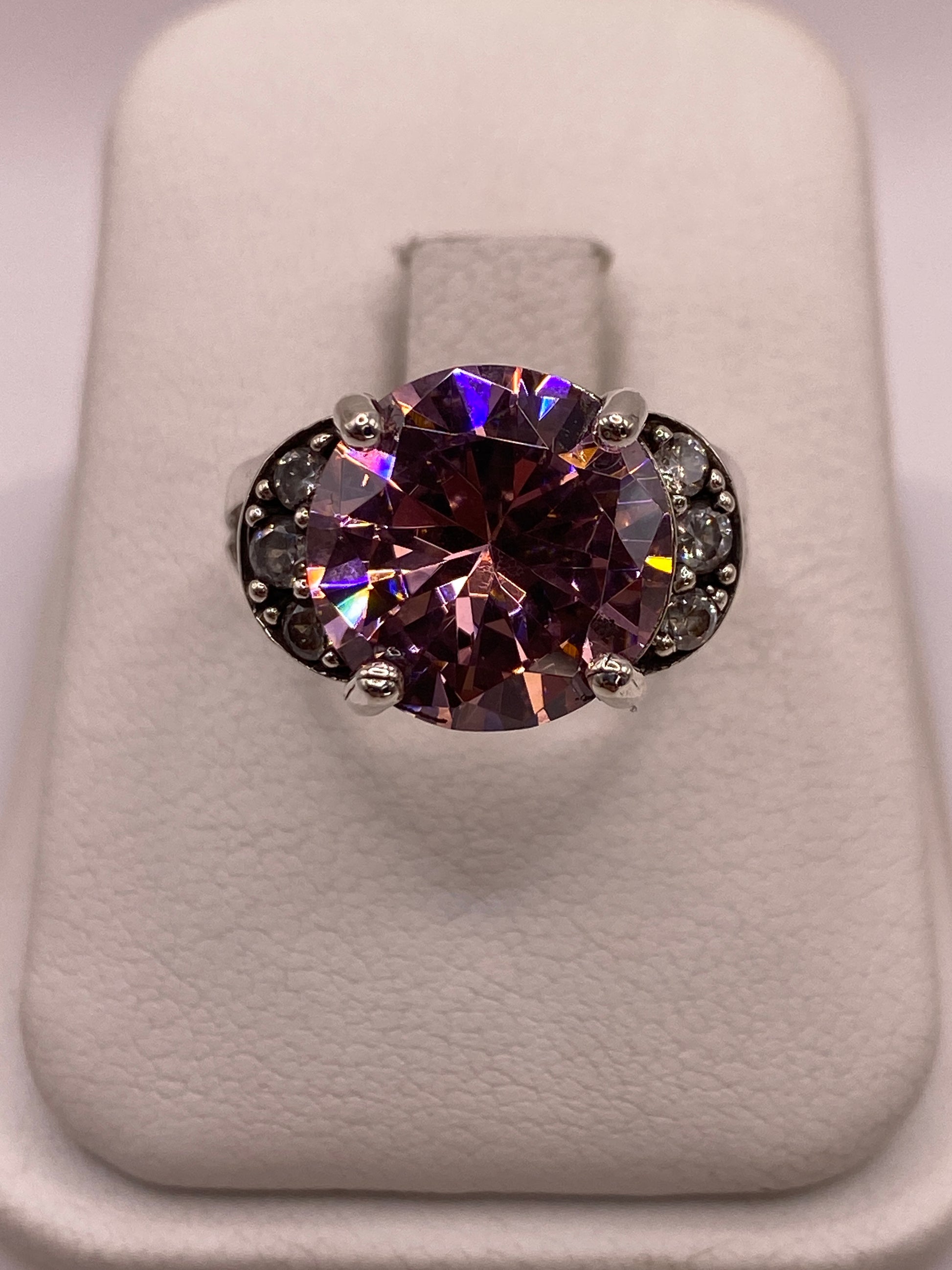 Anillo de plata coctel con circonia púrpura ovalada y pequenas circonias blancas laterales