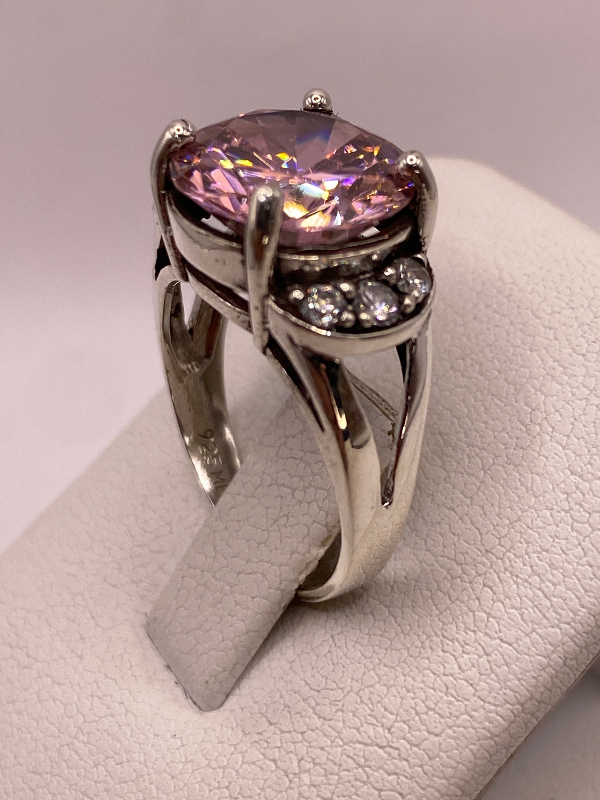 Anillo en la mano de una mujer luciendo el destello púrpura y blanco de la circonia