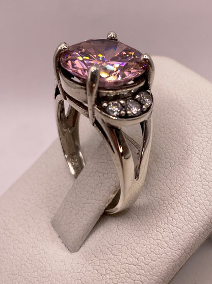 Anillo en la mano de una mujer luciendo el destello púrpura y blanco de la circonia
