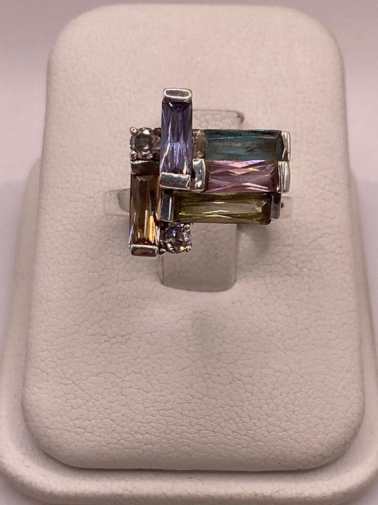 Anillo de plata con circonias multicolor en azul, rosa, verde y amarillo sobre dedo