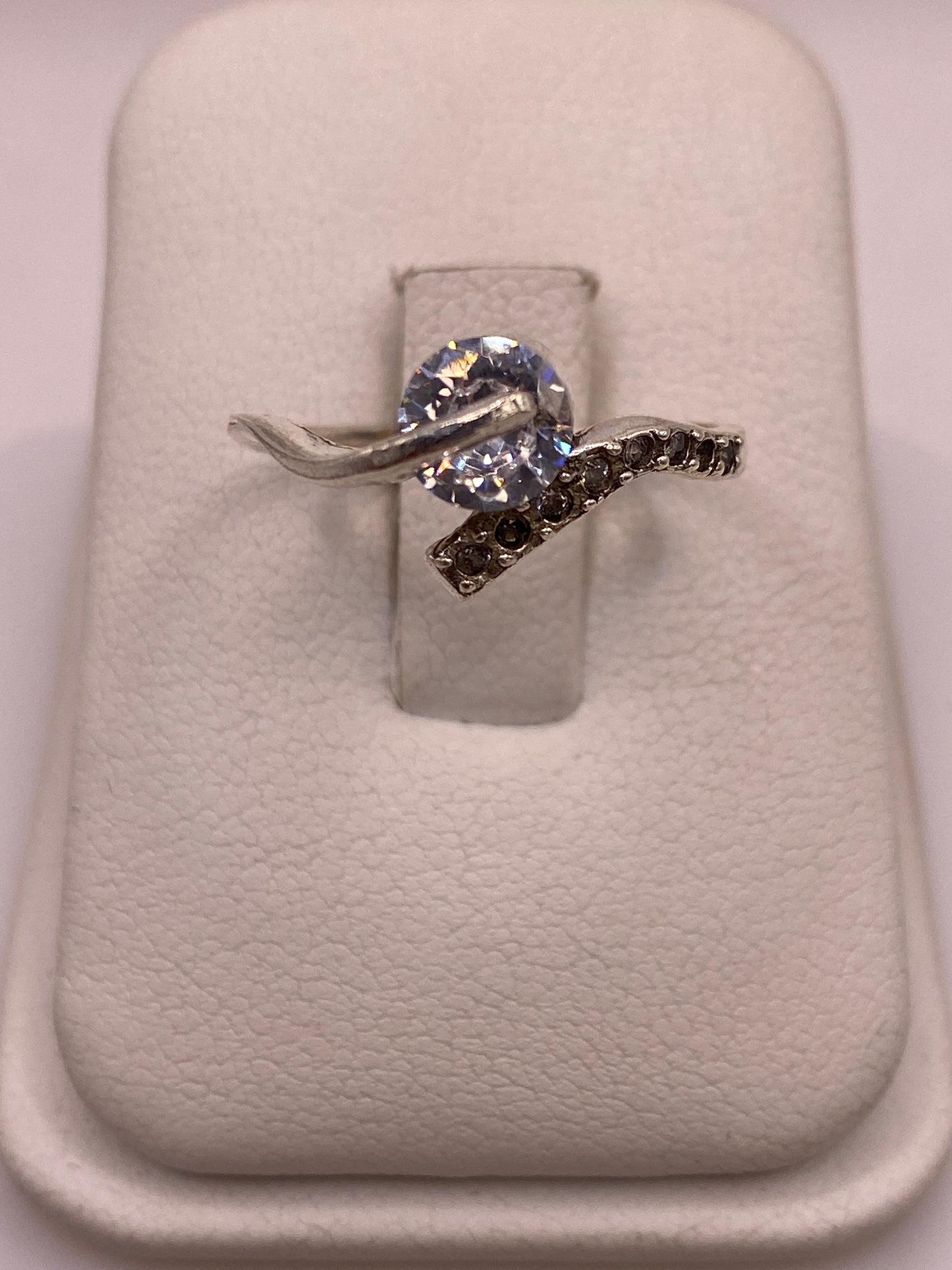 Anillo solitario de plata con circonia blanca engastada a mano en la mano de una mujer