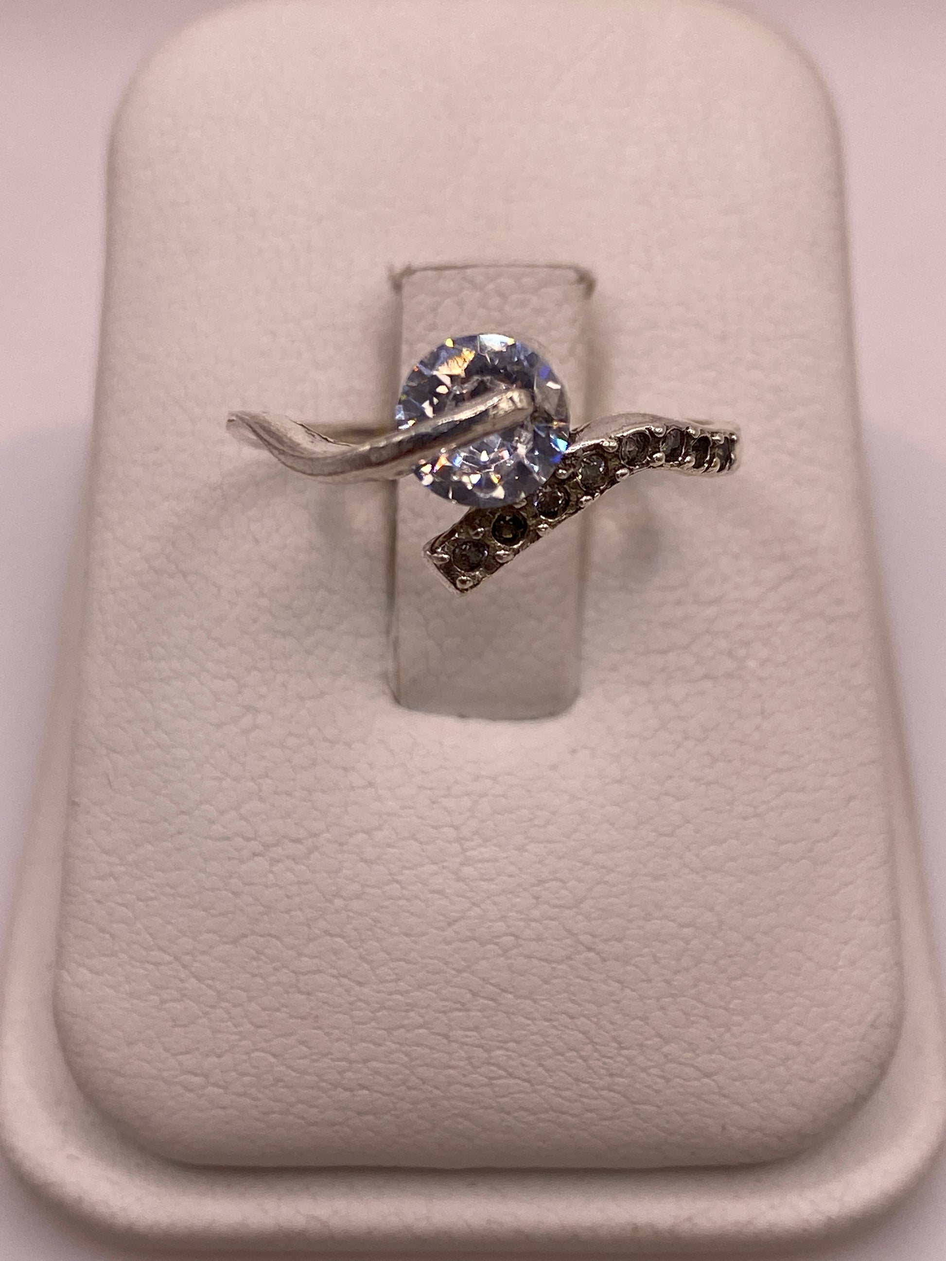 Anillo solitario de plata con circonia blanca engastada a mano en la mano de una mujer