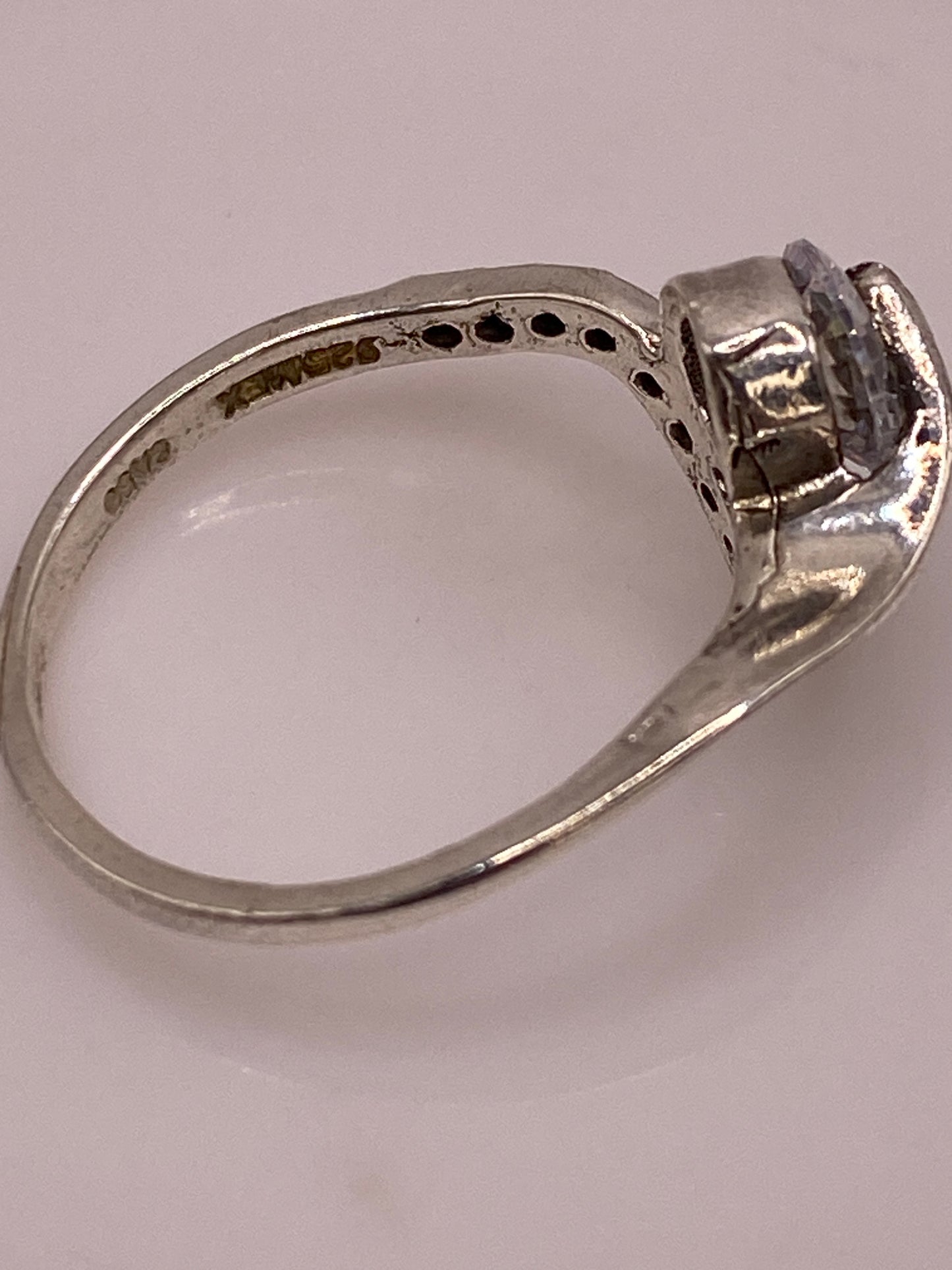 Anillo solitario sobre balanza mostrando peso de 2.3 gramos y marca de autenticidad