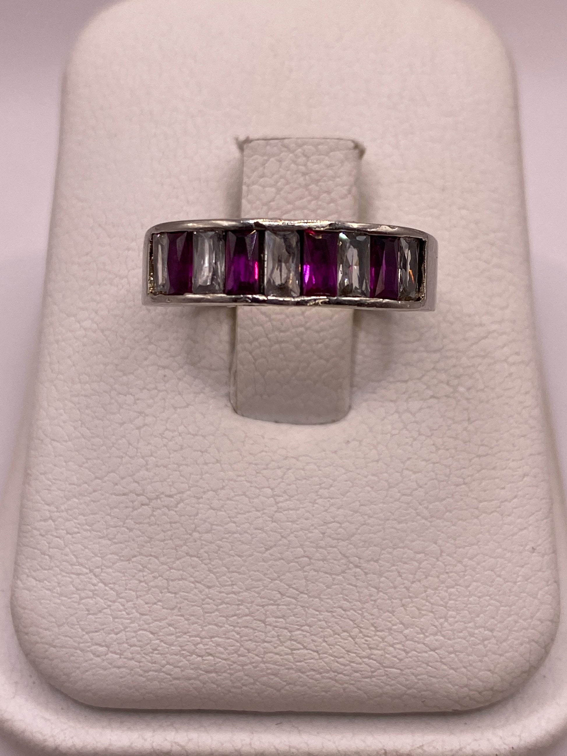 Anillo de plata minimalista con circonia púrpura en la mano de una mujer