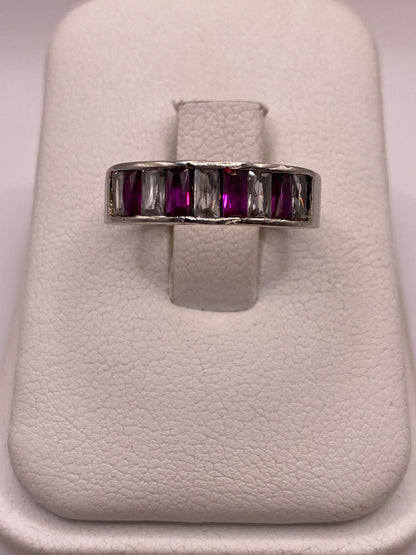 Anillo de plata minimalista con circonia púrpura en la mano de una mujer
