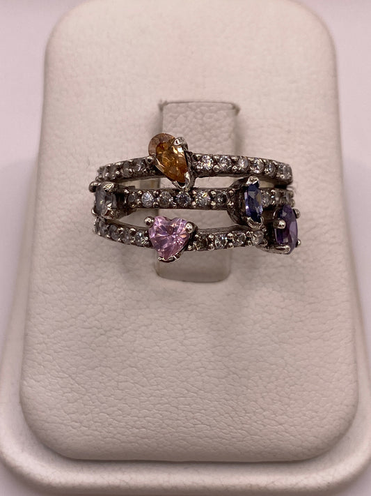 Anillo de plata .925 con racimo de circonias en tonos ámbar, púrpura y azul sobre estuche blanco