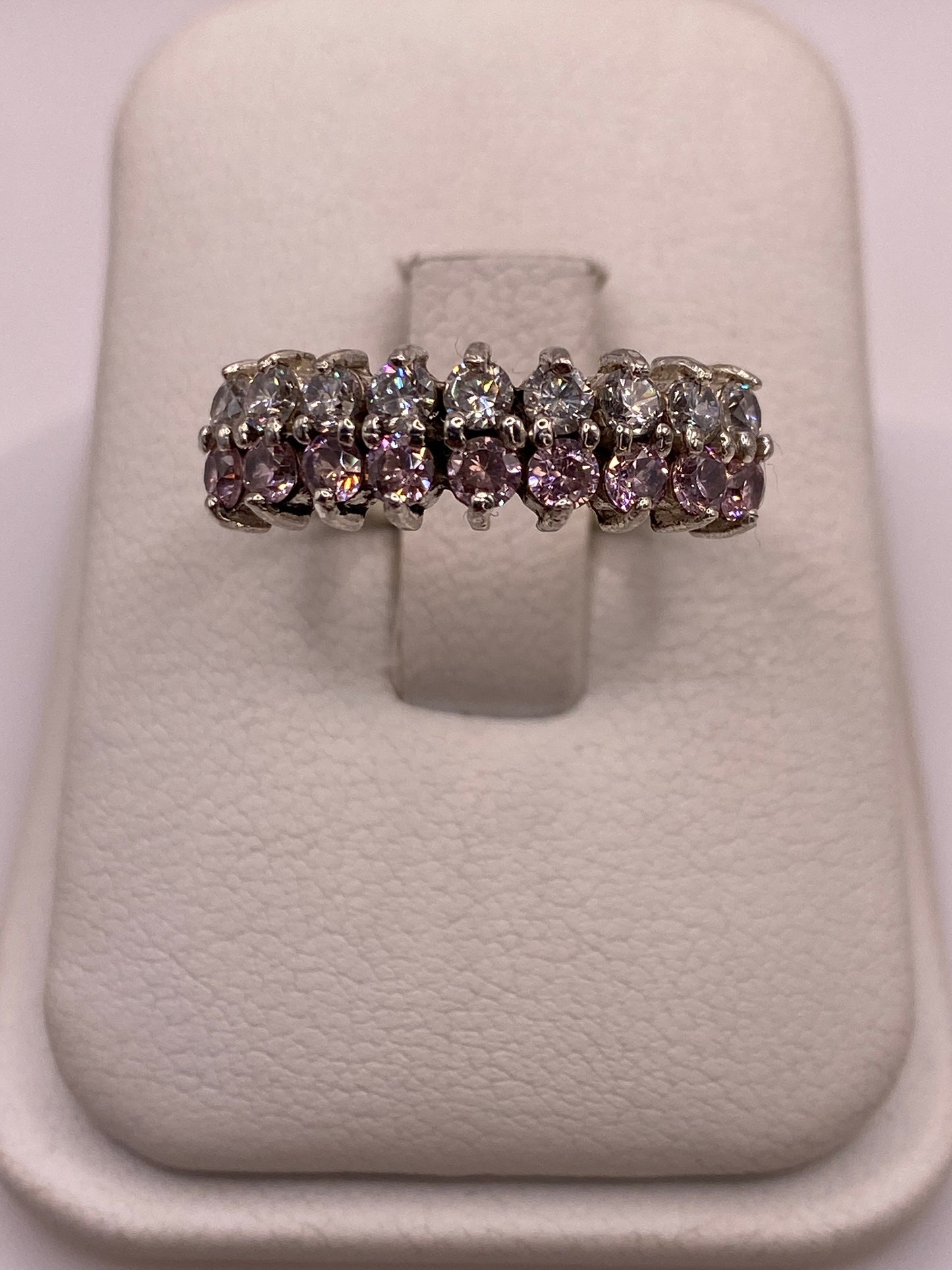 Anillo de plata .925 con 7 circonias blancas y lila graduadas en la mano de una mujer