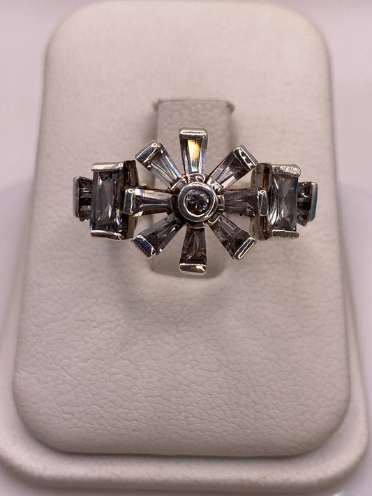 Anillo de plata .925 con arco de ocho circonias blancas y ahumadas, visto de frente sobre estuche blanco