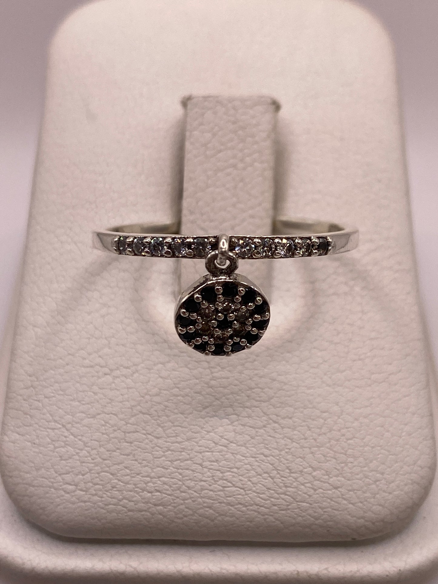 Anillo de plata solitario con circonia blanca brillante en la mano de una mujer