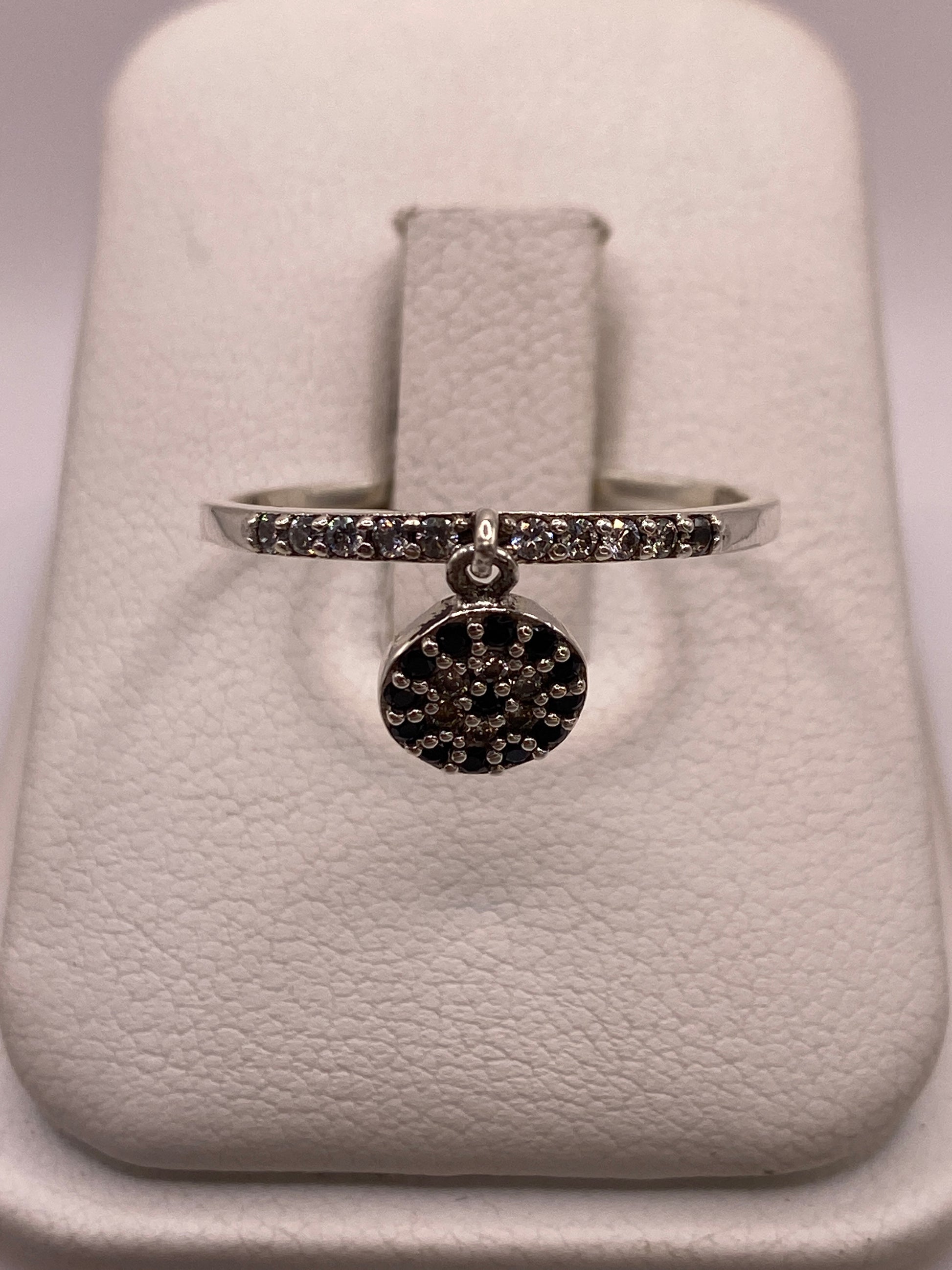 Anillo de plata solitario con circonia blanca brillante en la mano de una mujer