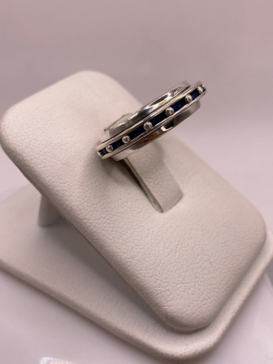 Anillo de plata clásico con circonias azules engastadas, vista lateral en mano