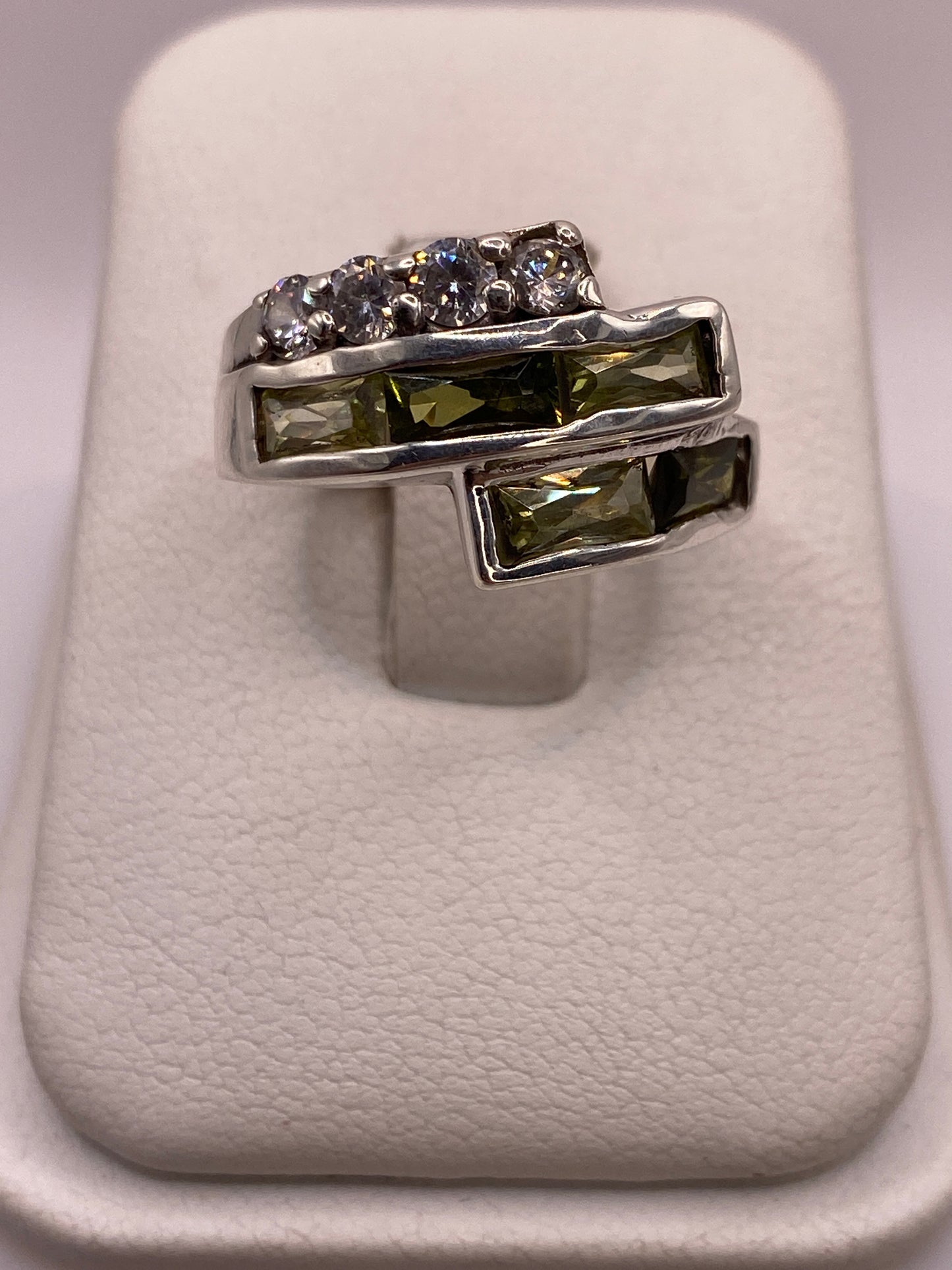 Anillo de plata arquitectónico con dos filas de circonias blancas y verdes en la mano de una mujer