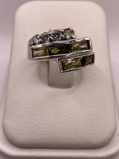 Anillo de plata arquitectónico con dos filas de circonias blancas y verdes en la mano de una mujer
