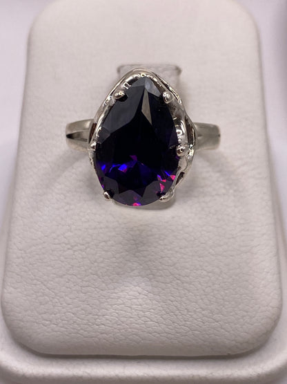 Anillo de plata solitario con circonia azul profundo en la mano de una mujer