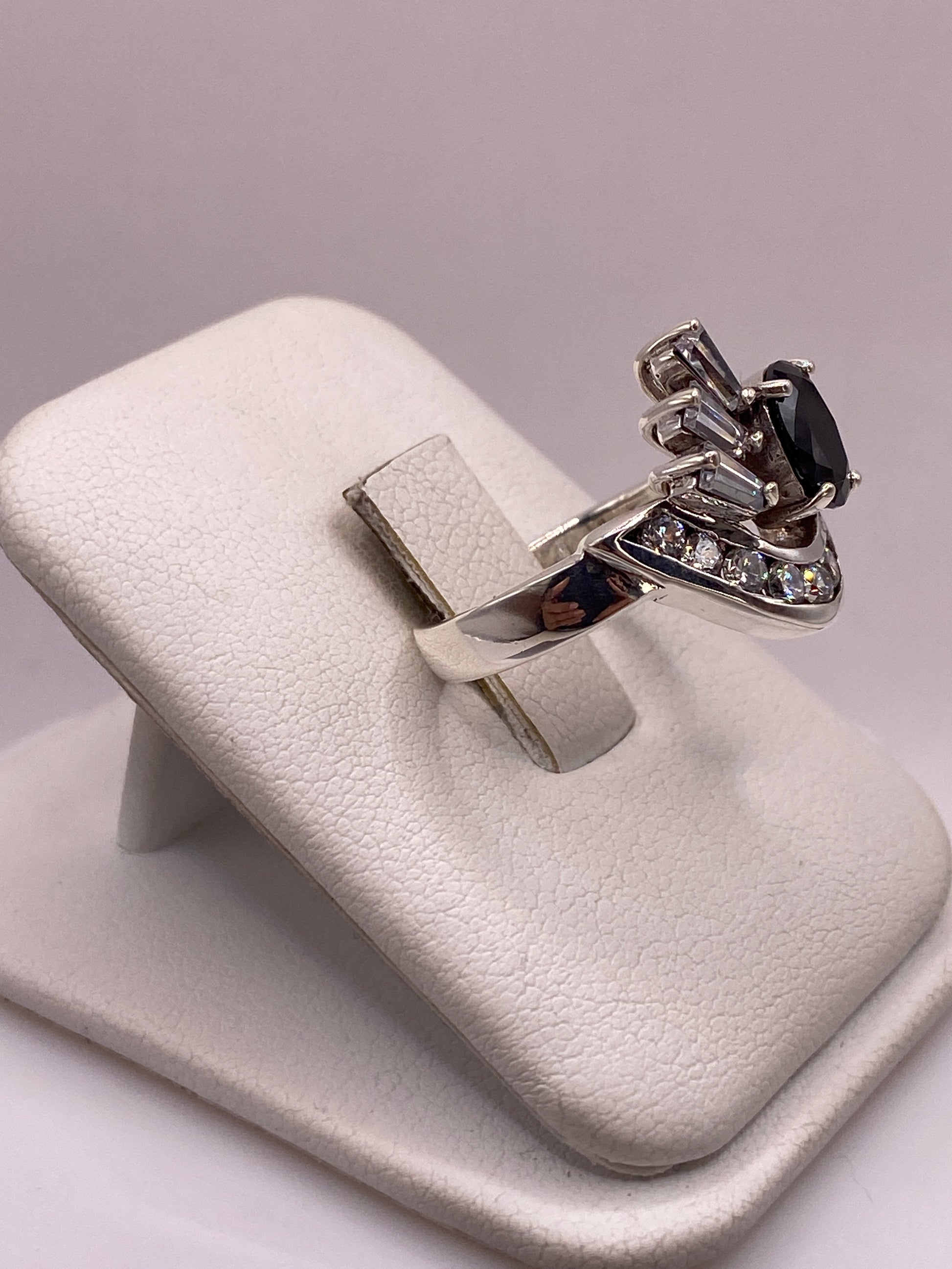 Anillo de plata sobre la mano mostrando el brillo y el fuego de las circonias negra y blanca
