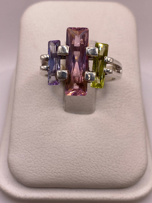 Anillo de plata vintage con tres circonias multicolor (amatista, peridoto, amatista) en la mano de una mujer