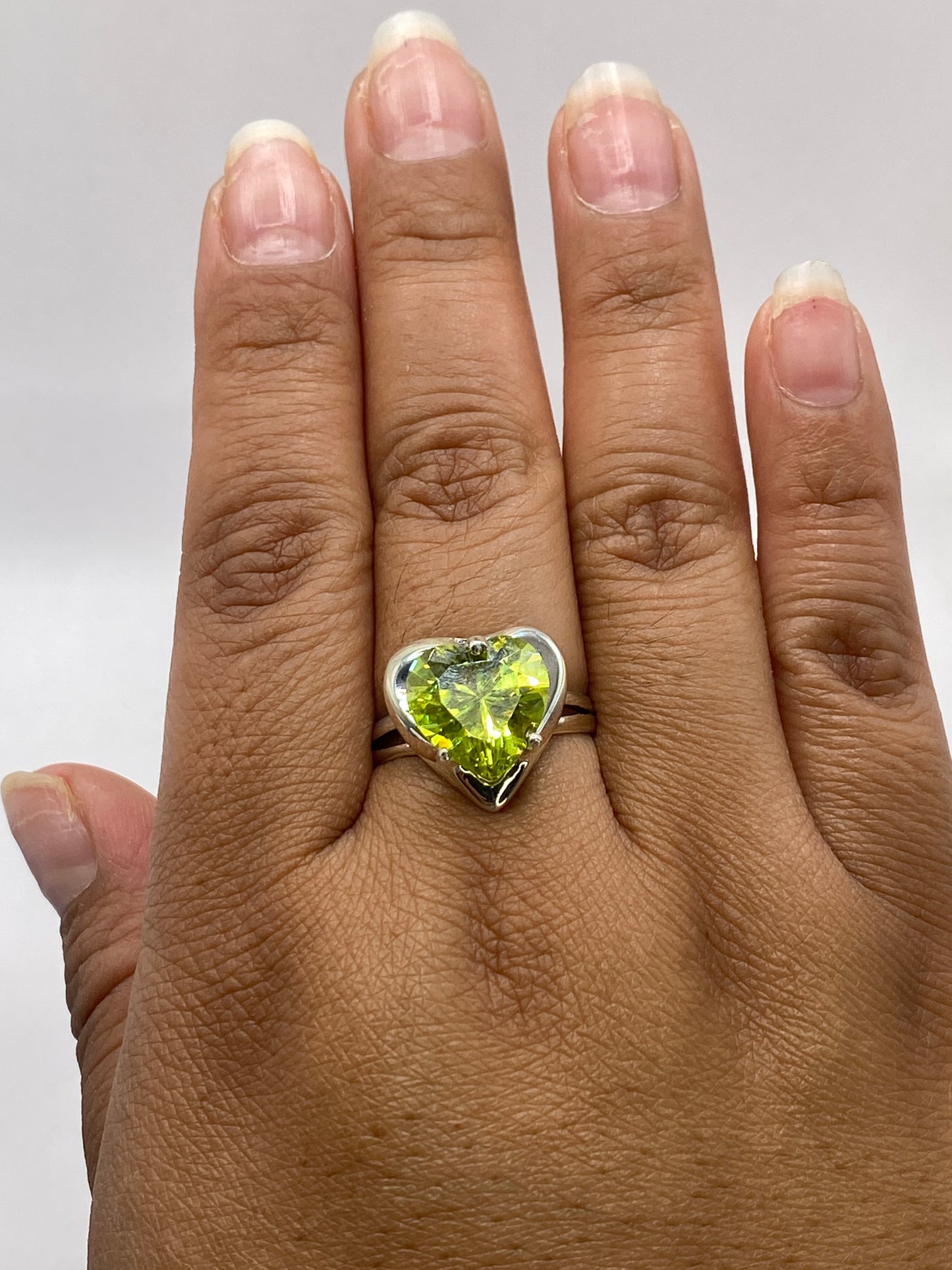 Anillo en mano mostrando el color y tamaño real de la circonia verde limón