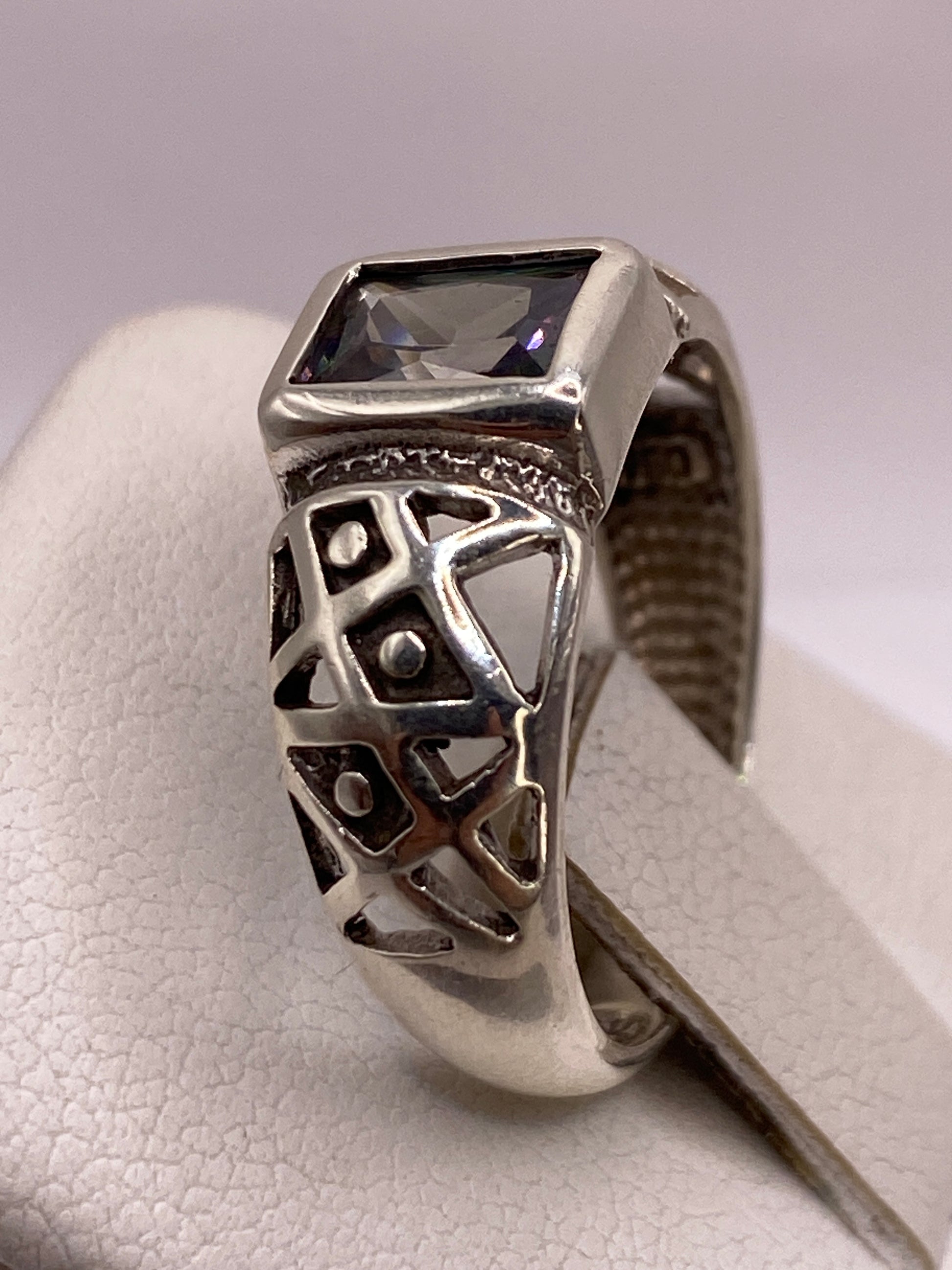 Detalle del anillo solitario en la mano, reflejando luz con fuego tipo diamante