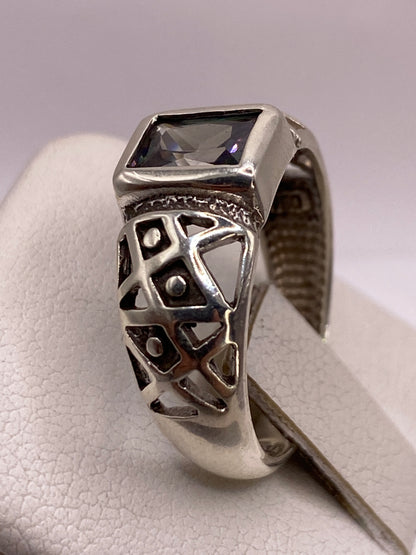 Detalle del anillo solitario en la mano, reflejando luz con fuego tipo diamante