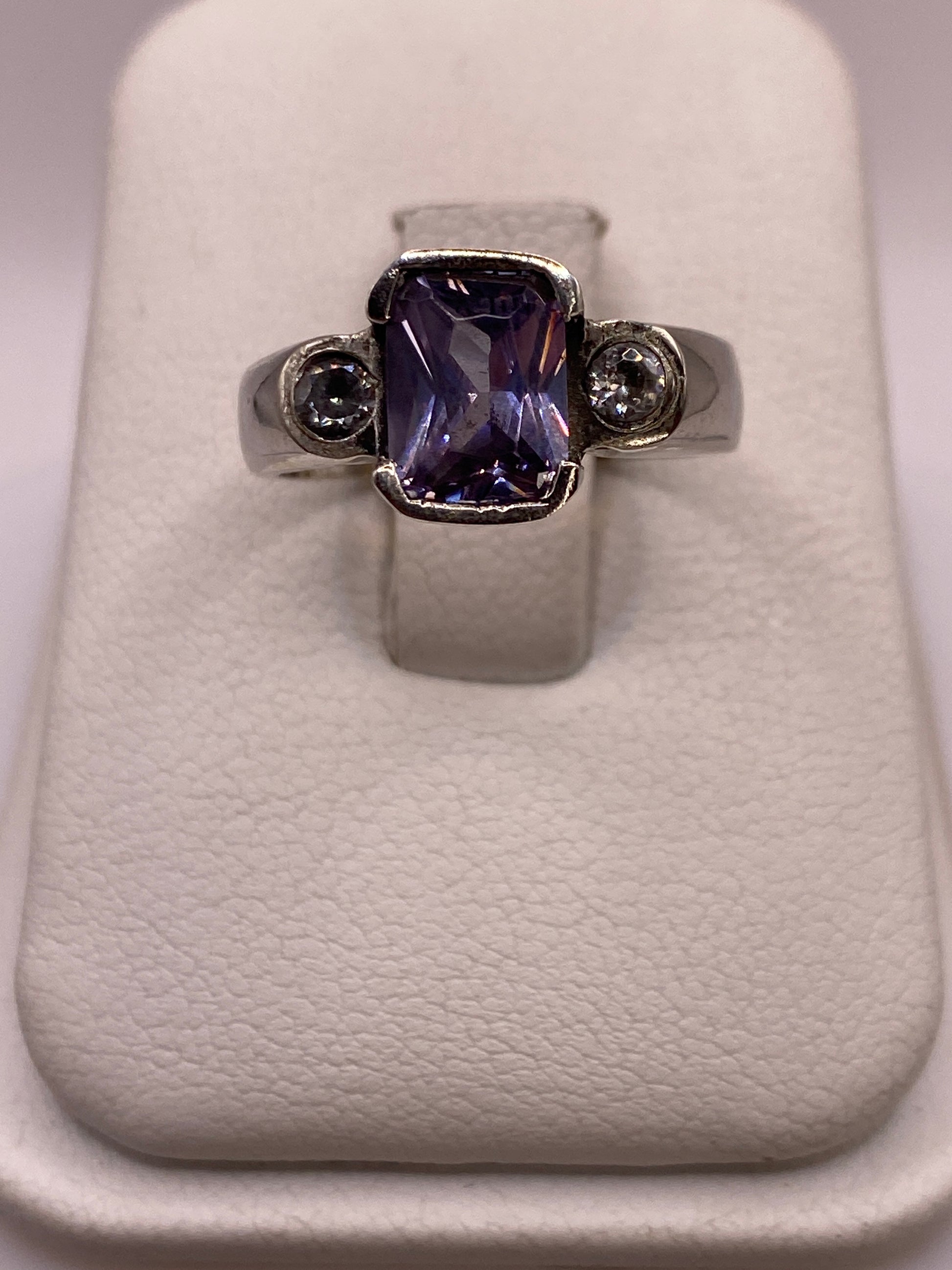 Anillo solitario de plata con circonia violeta profunda en caja de presentación blanca