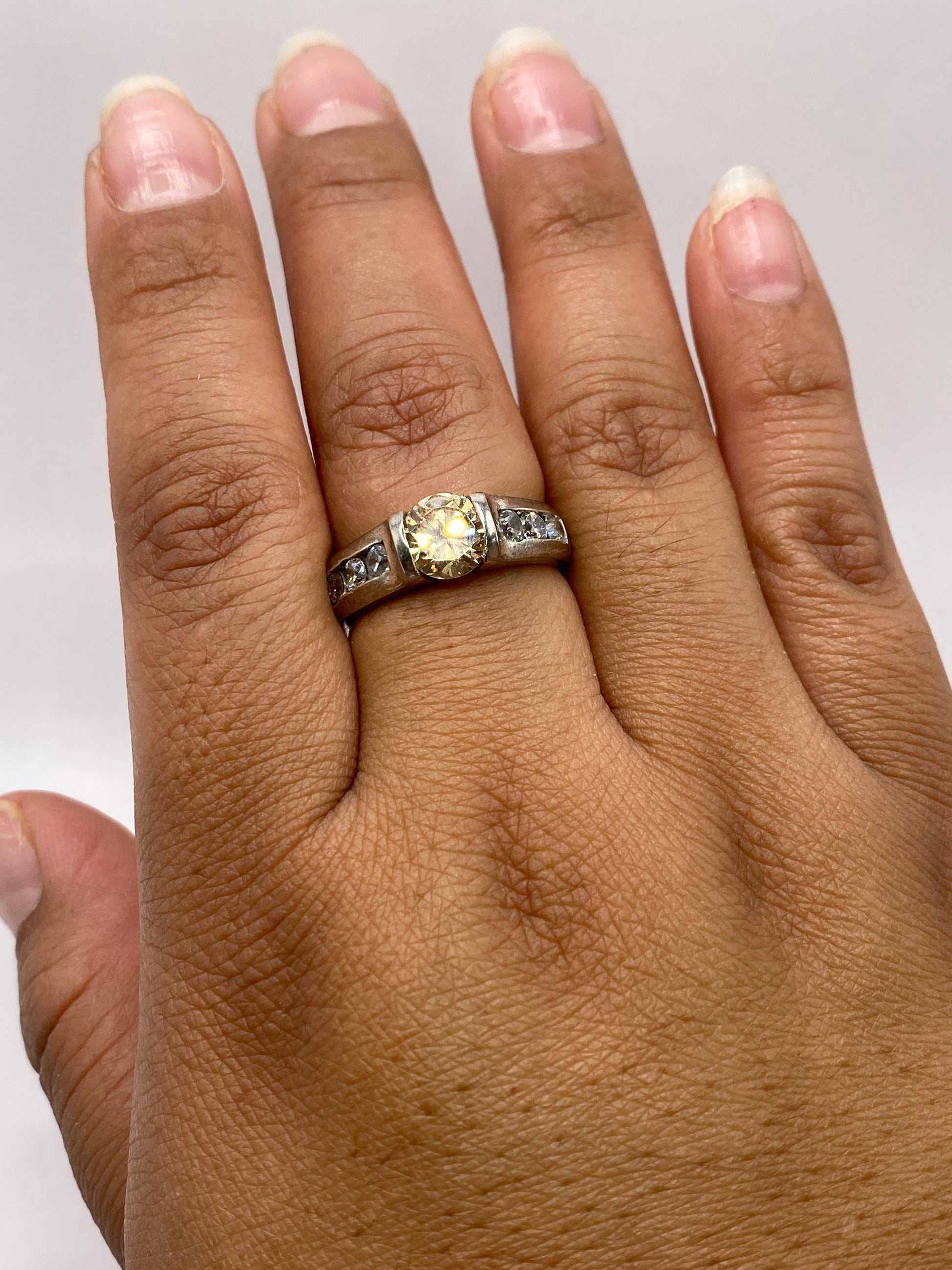 Anillo solitario en la mano mostrando el brillo y fuego de la piedra