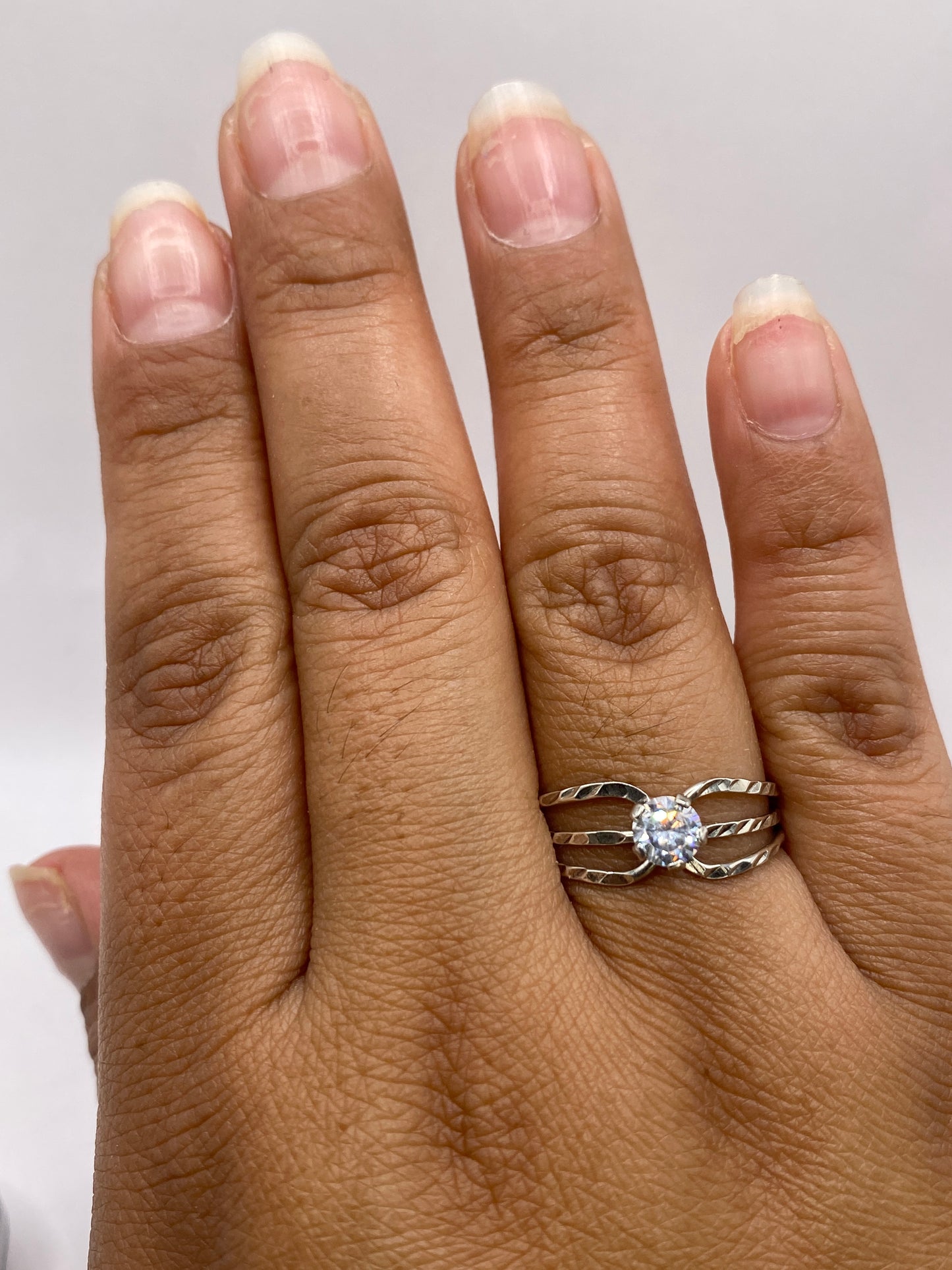 Detalle del anillo solitario sobre fondo neutro destacando el brillo y el pulido de la plata