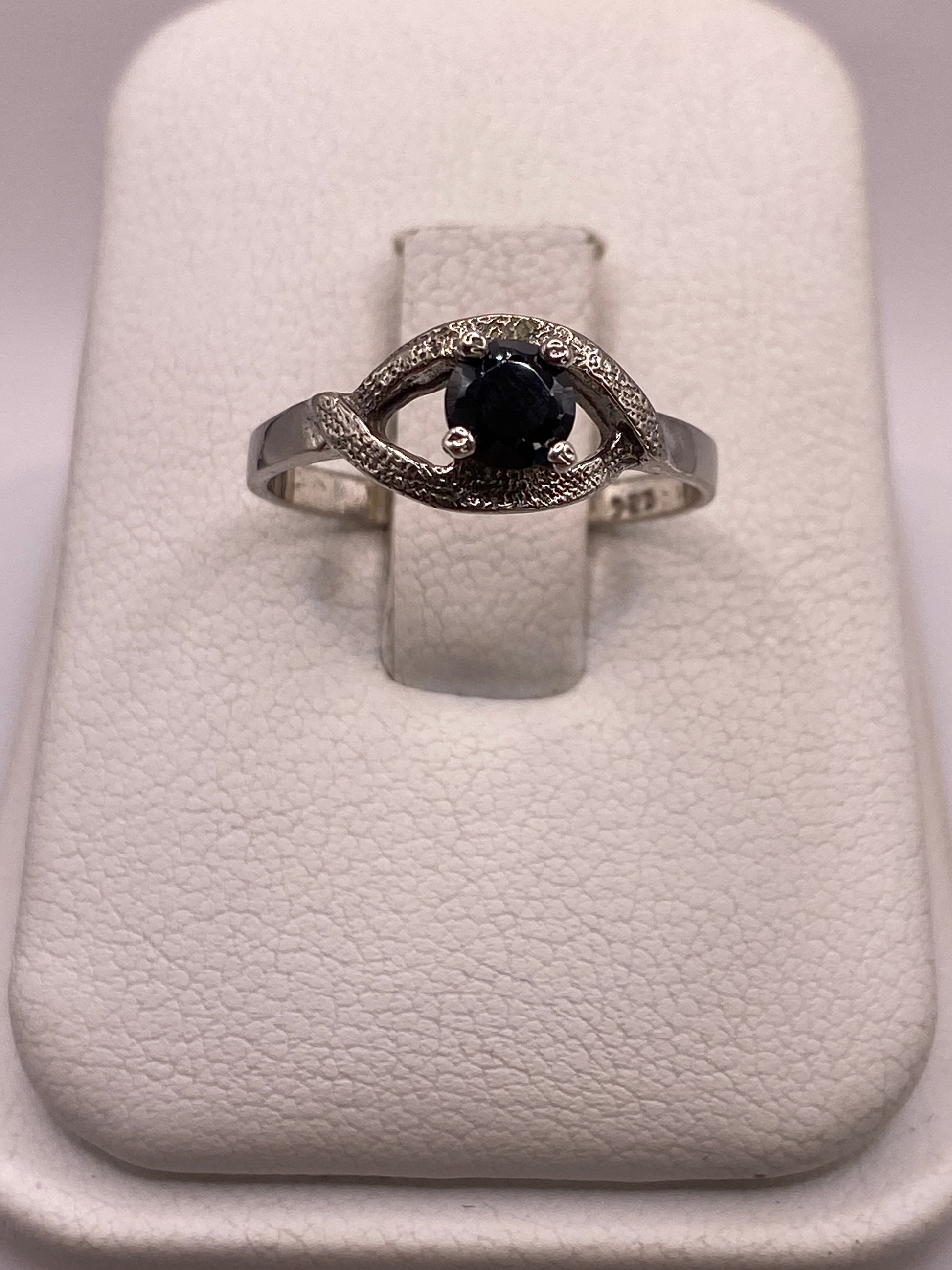 Anillo solitario de plata con circonia negra brillante, frente frontal sobre fondo blanco